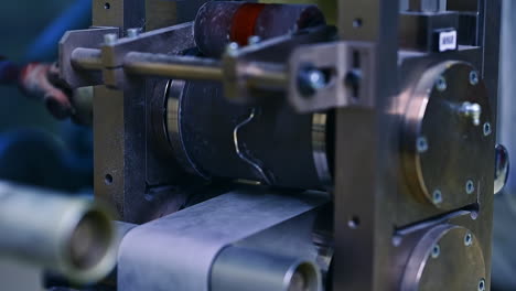 technological equipment for producing diapers at the factory. shafts and rollers spinning at conveyor line. close up.