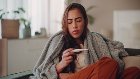 woman checking her temperature with a thermometer