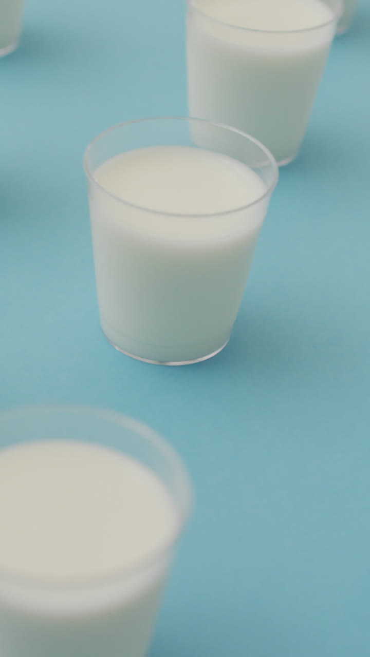 파란색 배경 에 있는 우유 컵 의 줄 의 비디오