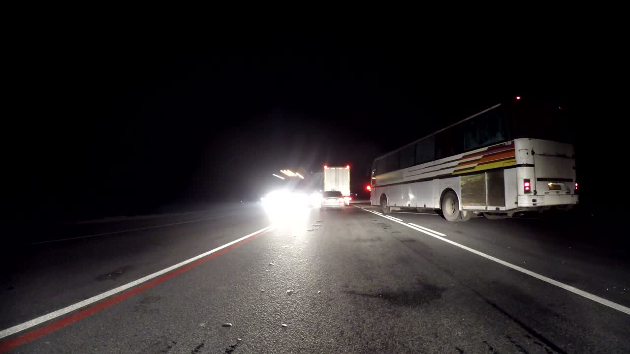 밤에 오래된 시골 도로를 운전하는 빠른 자동차. 향하는 트럭의 흐름. 밤에 오래된 도로 타임스 (하이퍼스) 를 운전하는 자동차. 밤에 고속도로에서 하이퍼스를 운전하는 카메라가 차량 바에 배치되어 있으며 차량의 수준은 수평입니다.