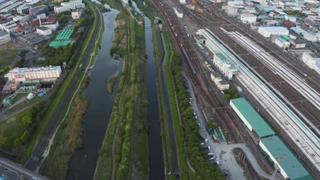 Vista-Aérea-De-Los-Suburbios-De-Osaka-De-La-Ciudad-De-Kadoma-Con-Tren-Bala-Pasando-4k