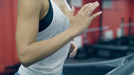 close view slim girl in sportswear runs on modern treadmill