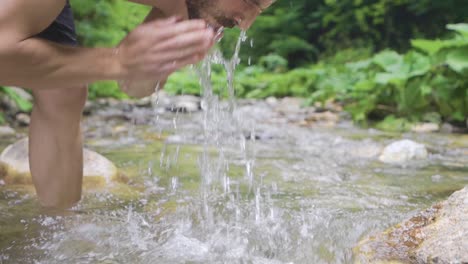 hombre deportivo frente a la cascada. cámara lenta.
