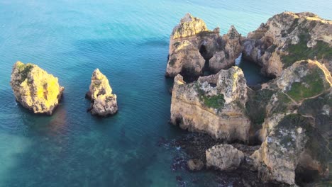volando sobre aguas azules claras entre arcos naturales y formaciones rocosas de torres
