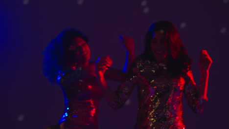 Close-Up-Of-Two-Women-In-Nightclub-Bar-Or-Disco-Dancing-With-Falling-Gold-Confetti