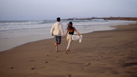 couple enjoy summer vacation on the large beach, enjoy life and running in scenery slow motion video on background ocean landscape. young couple running into tropical ocean rare view