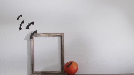 Video-of-frame-with-copy-space,-halloween-decorations-and-pumpkin-on-white-background