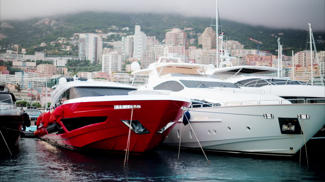 View of boats docked in the Monaco Marina with the skyline of the city on the background