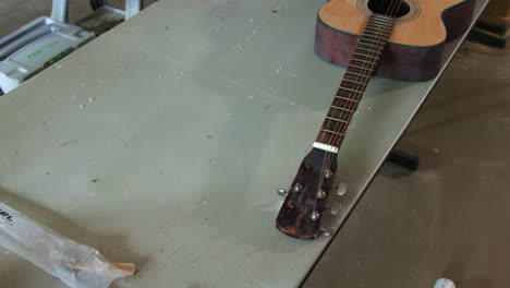 camera-dolly's-across-a-table-showing-an-old-beat-up-guitar