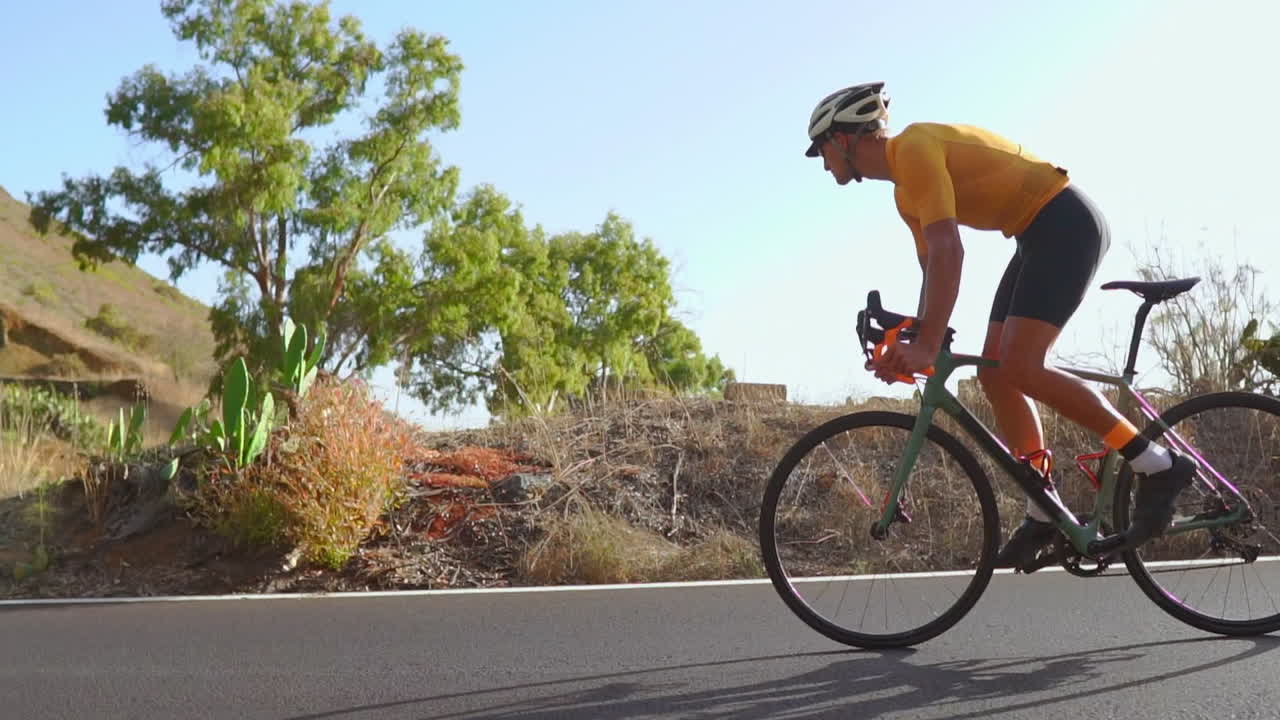 한 남자가 빈 도로에서 아침 자전거를 타고 야외 운동을 하고 있습니다. 슬로우 모션 영상은 익스트림 스포츠의 본질을 포착합니다.