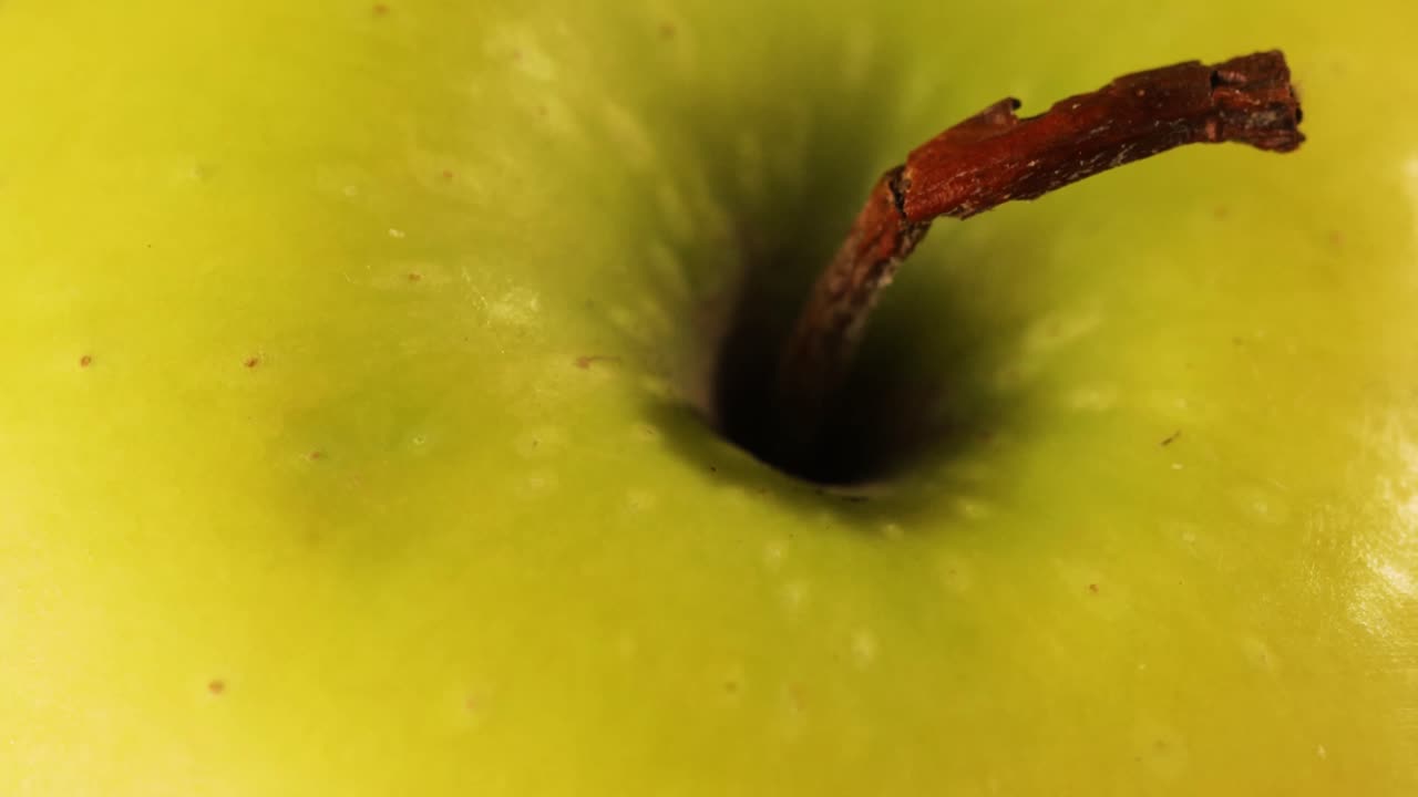 foto de detalle del producto de la parte superior de una manzana verde con tallo roto