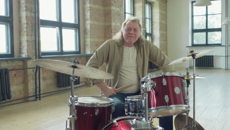 portrait of senior drummer in music studio