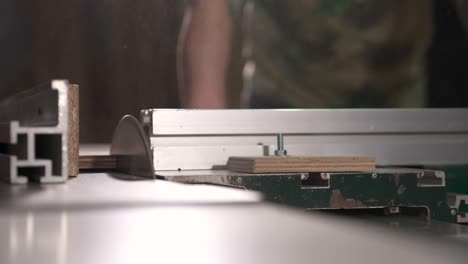 a side view of a table circular saw making a cross-cut of a wood piece