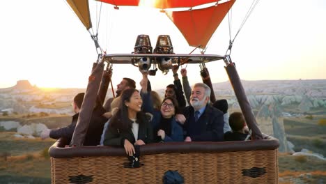 enjoy a thrilling hot air balloon ride over the stunning cappadocia landscape as the sun rises. this unforgettable experience captures smiles and shared joy among friends.