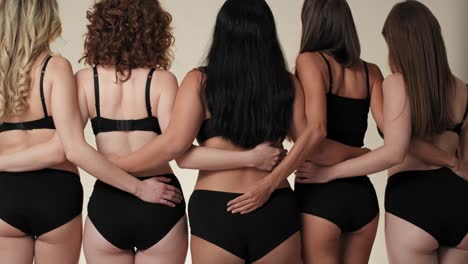 Tilt-up-of-women-in-black-underwear-standing-and-turning-towards-the-camera.