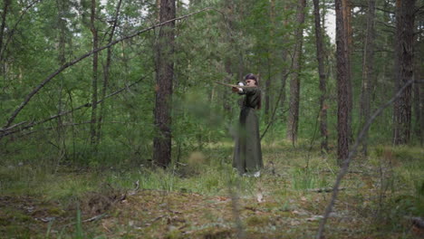 Teen-girl-in-dress-shoots-crossbow-at-quest-in-pine-forest