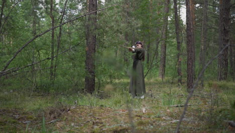 Una-Adolescente-Vestida-Dispara-Una-Ballesta-En-Una-Misión-En-Un-Bosque-De-Pinos