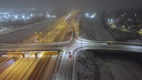 Coches-Circulando-Por-Una-Carretera-Nevada-Por-La-Noche-En-Invierno-En-Montreal,-Quebec,-Canadá