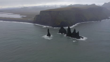 aerial: flying towards reynisfjara black sand beach during harsh weather