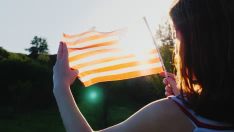 Two-Female-Twins-With-An-American-Flag-On-A-Blue-Sky-Background