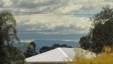 grandes nubes rodantes se mueven sobre el monte wellington sol en el techo de estaño ventoso durante el día australia victoria gippsland maffra