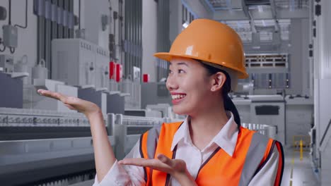 close up of asian female engineer with safety helmet smiling and pointing to side at pharmaceutical factory, vaccine production facility