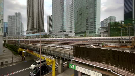 bullet trains pass over tokyo street