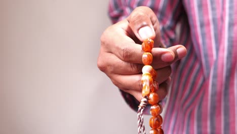 person holding prayer beads