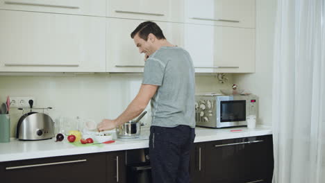 Glücklicher-Mann,-Der-In-Der-Küche-Ein-Gesundes-Abendessen-Kocht.