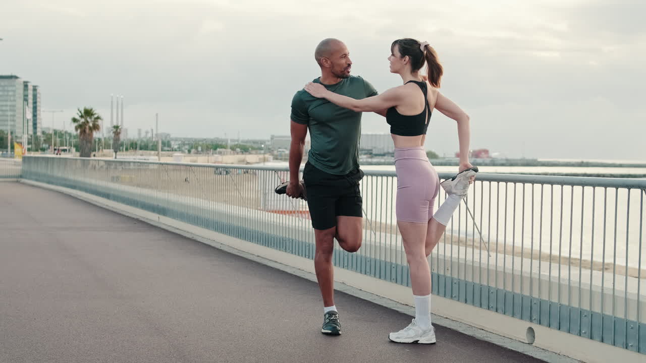 Couple Stretching Legs Together on Urban Promenade by the Sea