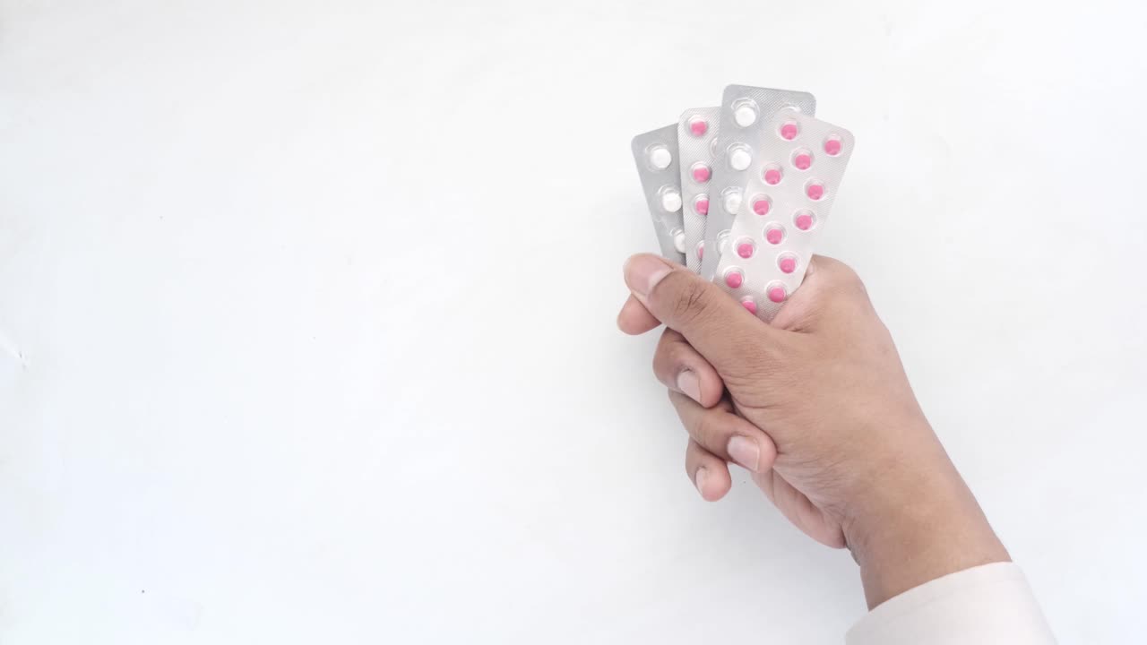 Mano sosteniendo un envase de medicamento