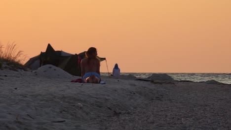 una mujer haciendo yoga en la playa por la mañana