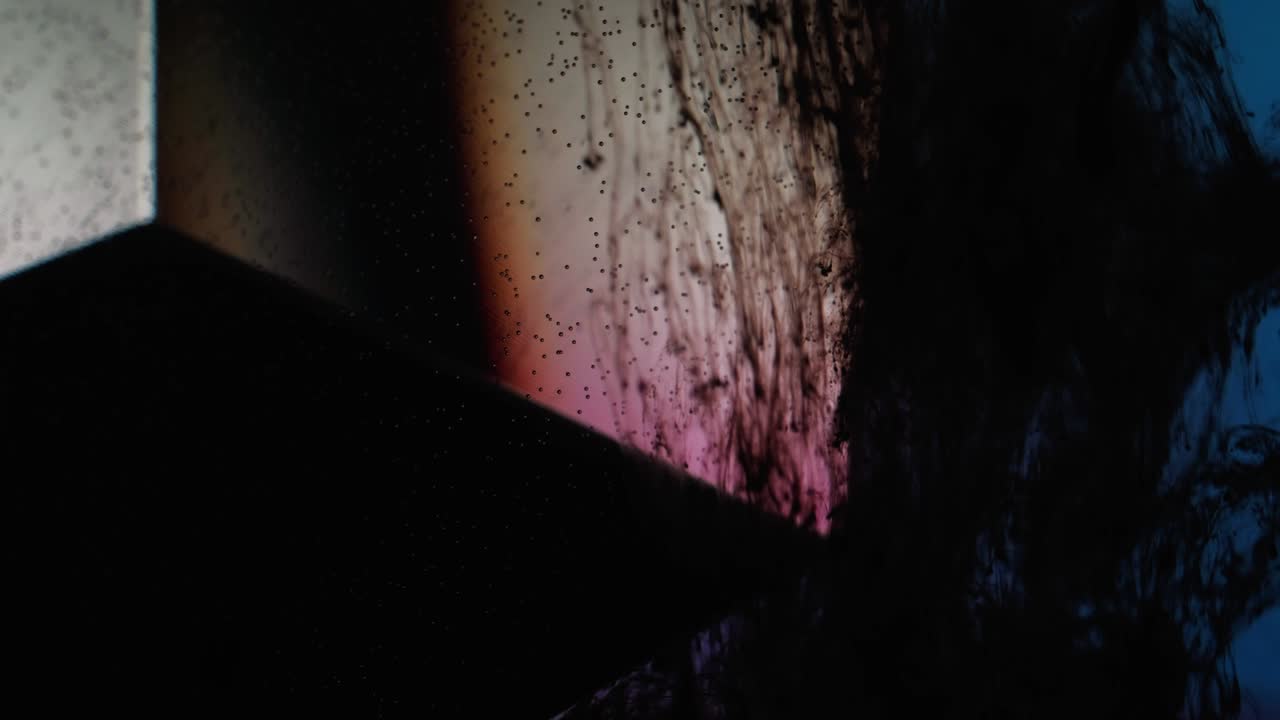 flujo de humo líquido negro goteo cubo de vidrio agua azul