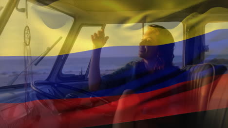 Animación-De-Una-Mujer-Sentada-En-Una-Camioneta-En-La-Playa-Con-La-Bandera-De-Colombia-Ondeando-Sobre-Una-Escena