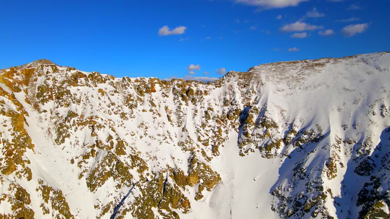 Flying over mountains covered in snow in Summit County Colorad. Aerial wide shot.
