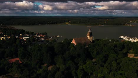 Toma-Aérea-De-Seguimiento-De-La-Iglesia-Y-El-Casco-Antiguo-Del-Puerto-De-Naantali,-Verano-En-Finlandia.