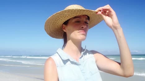 Beautiful-woman-wearing-hat-while-walking-at-beach