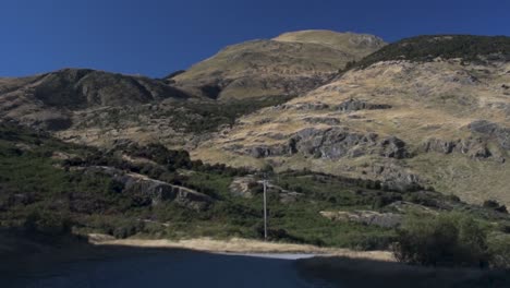 Driving-around-a-curve-on-a-gravel-road-through-the-mountain