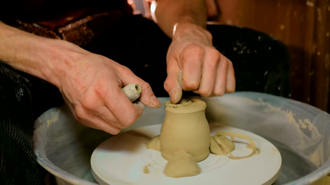 taza de conformación de alfarero profesional con herramienta especial en taller de cerámica