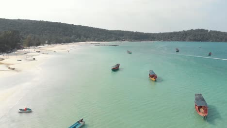 shoreline circling around shallow bay with fisher boats moored in saracen bay in koh rong sanloem, cambodia - aerial panoramic shot