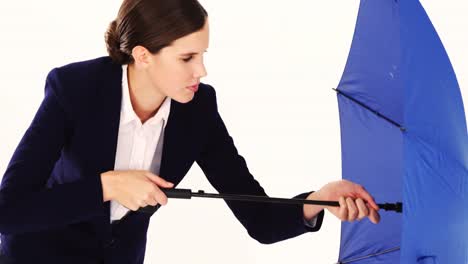 Businesswoman-trying-to-close-the-umbrella