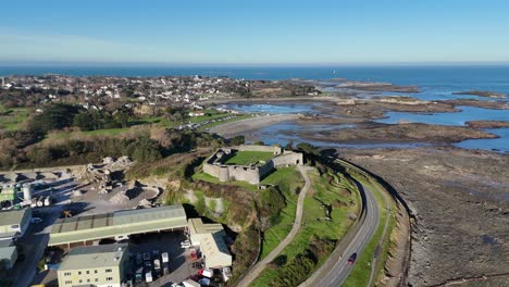 guernsey beautiful drone reveal of historic vale castle with views across to bordeaux at low tide with calm blue sea and late afternoon sun