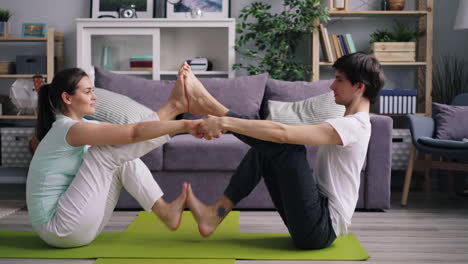 couple doing partner yoga at home