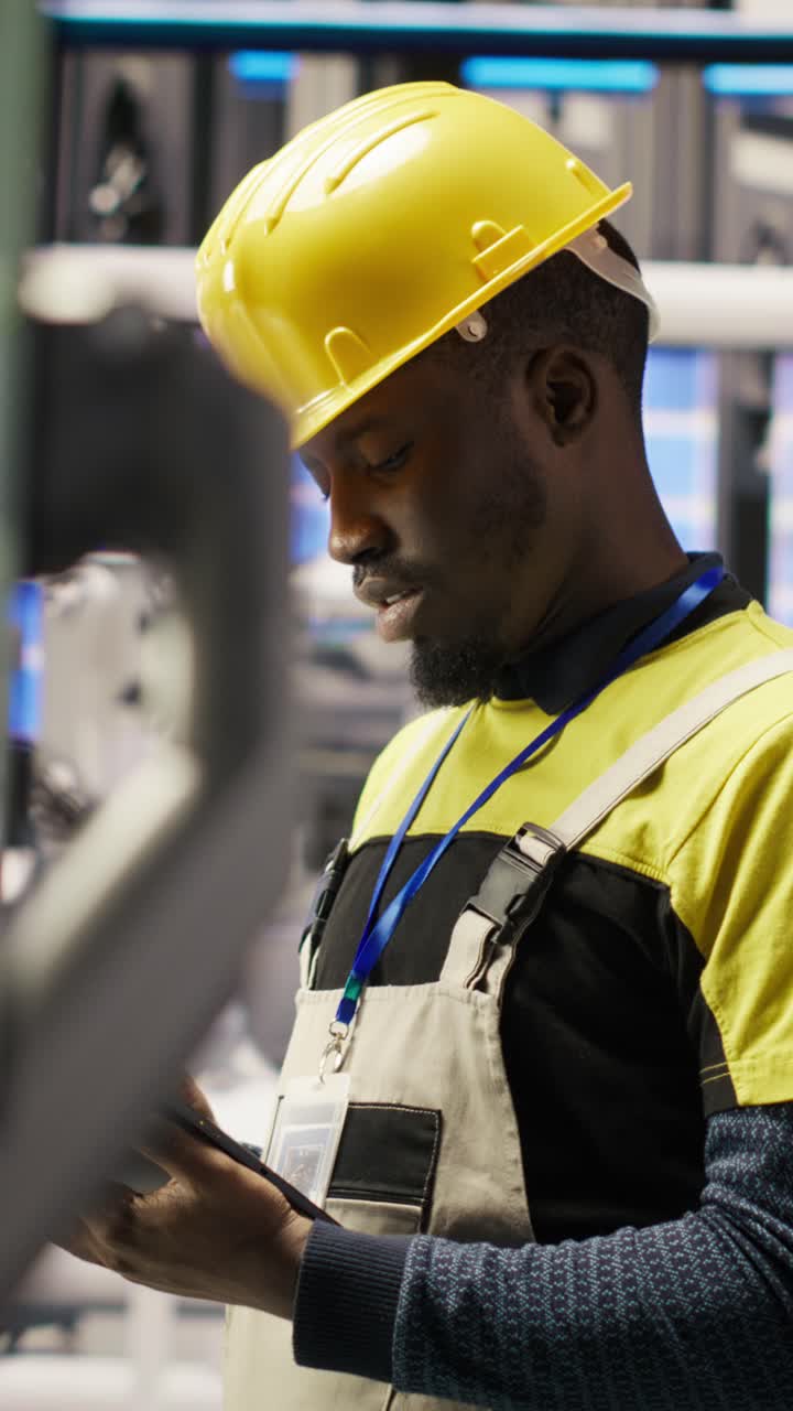 Vertical video Engineer oversees solar panel production lines equipment using tablet app
