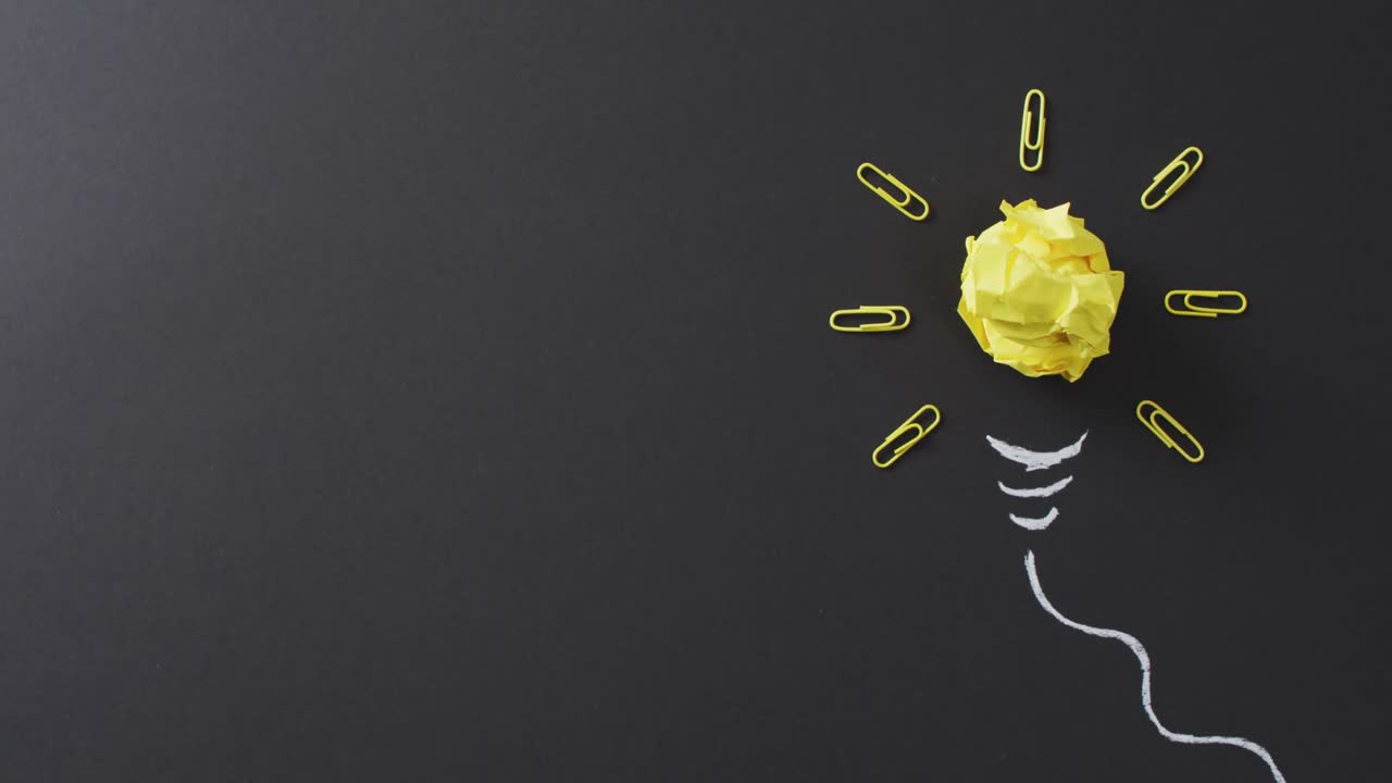 검은색 배경에 종이 공과 종이 클립으로 만든 전구의 비디오