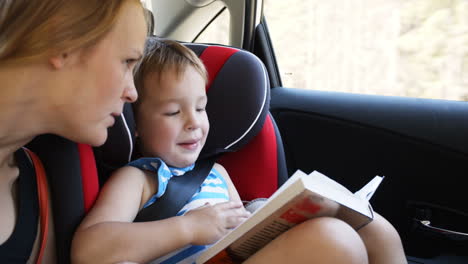 Madre-E-Hijo-Con-Libro-Viajando-En-Coche