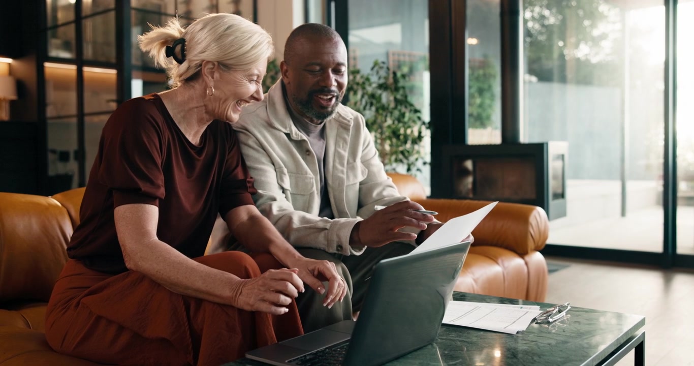 Mature Business Colleagues Collaborating on Laptop in Modern Office