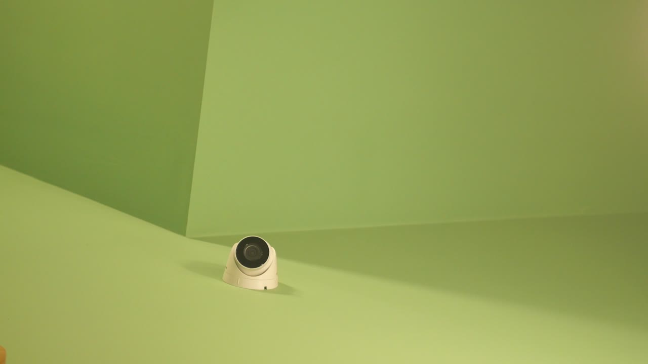 Security camera on a green wall