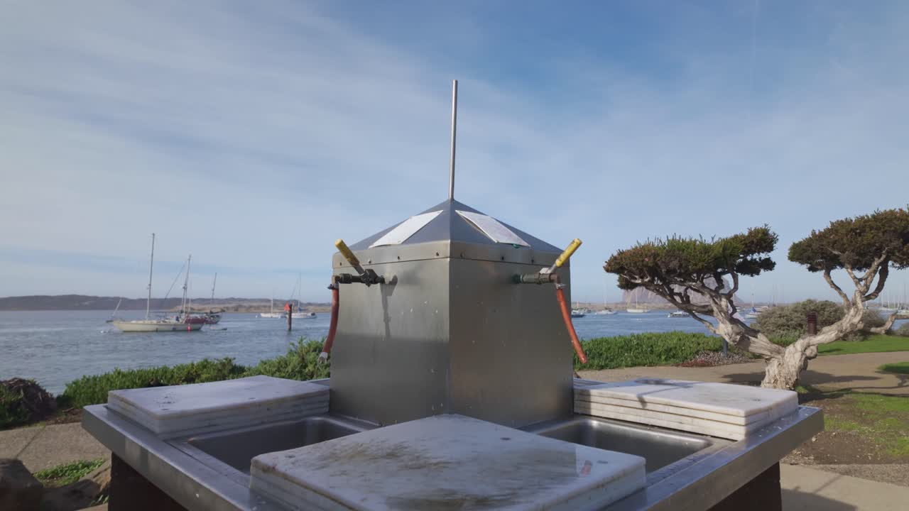 Gimbal close-up booming down shot of a public fish cleaning station at Tidelands Park in Morro Bay, California. 4K