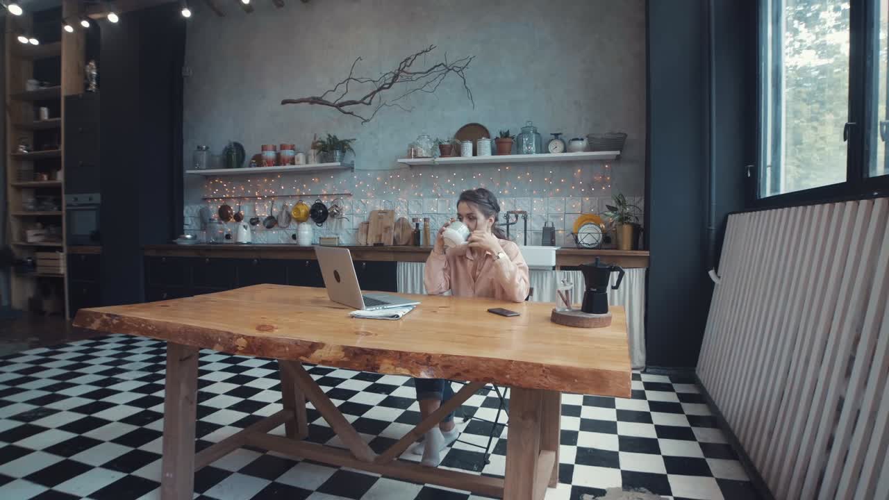 женщина работает из дома на современной кухне